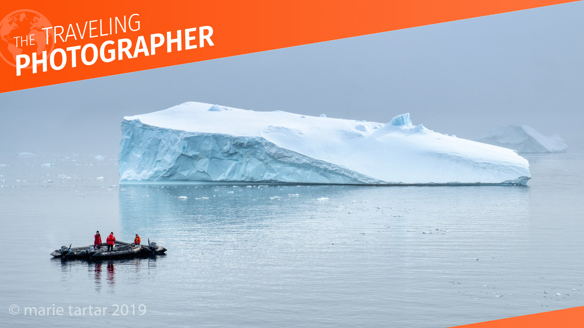 Travelers in a zodiac admire an iceberg in Antarctica